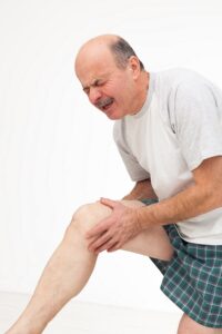 man rubs sore knee. Cry because of pain